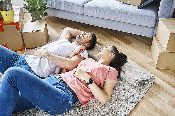 Happy couple relaxing while moving into new apartment