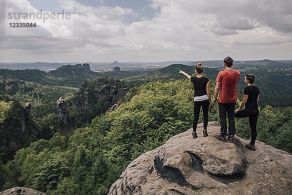 Germany  Saxony  Elbe Sandstone Mountains  friends on a hiking trip standing on rock