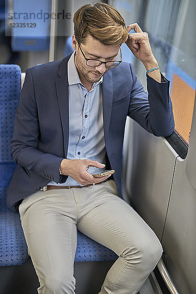 Businessman using smartphone in metro