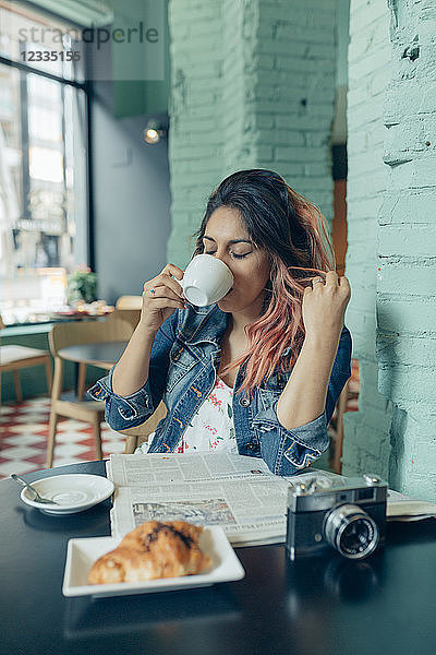 Woman sitting in coffee shop drinking coffee