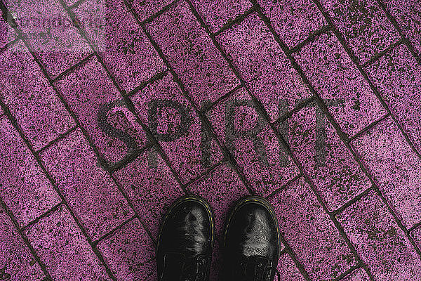 Black shoes on purple pavement with stenciled word 'Spirit'