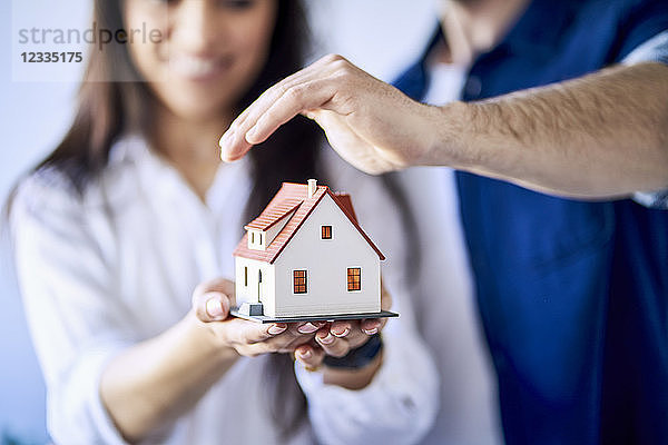 Close-up of couple holding model of new home