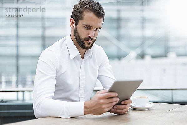 Young businessman using tablet in a cafe