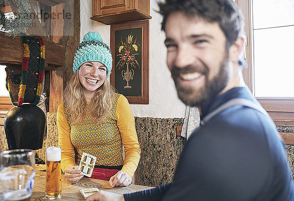 Happy couple playing cards in rustic mountain hut