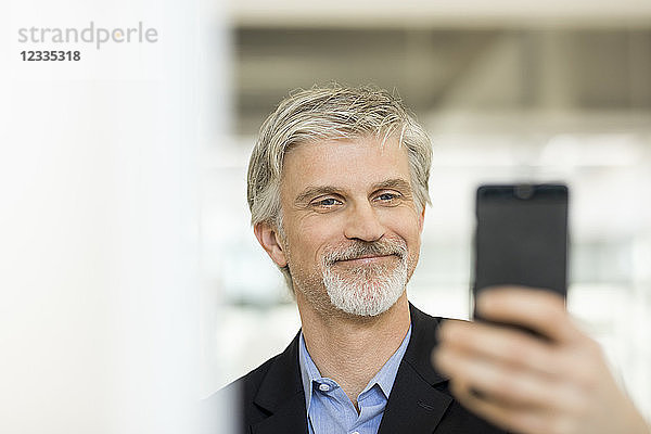 Mature man taking selfies with his smartphone