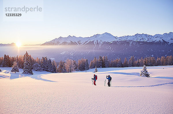 Austria  Tyrol  couple snowshoeing at sunrise