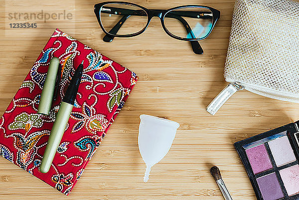 Menstrual cup on a table and notebook  pen and glasses