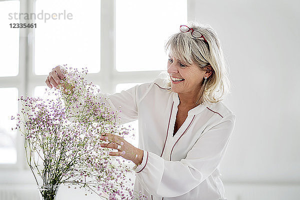 Smiling mature woman caring for flowers