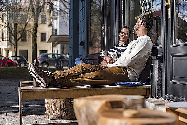 Man and woman sitting outside a cafe talking
