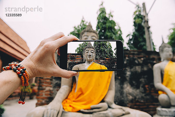 Thailand  Ayutthaya  Wat Yai Chai Mongkhon  taking a photo from Buddha with smartphone