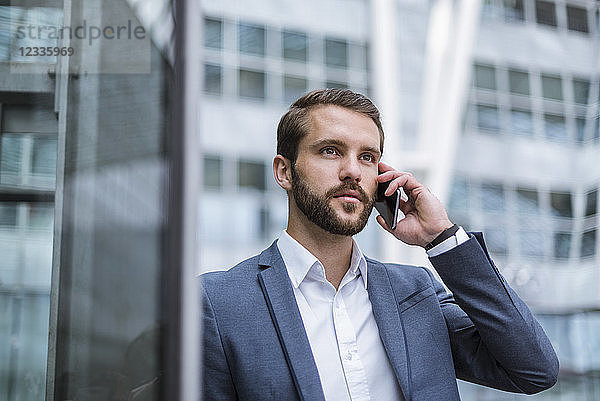 Young businessman on cell phone looking sideways