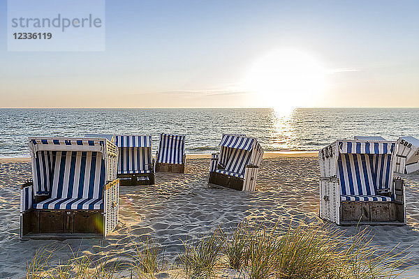 Germany  Schleswig-Holstein  Sylt  beach and empty hooded beach chairs at sunset