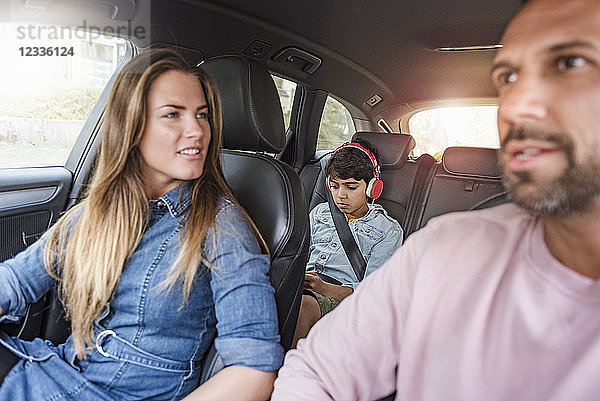 Family on a road trip with boy wearing headphones