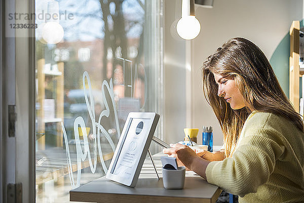 Young woman using tablet in a cafe
