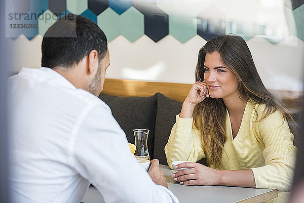 Young woman looking at man in a cafe