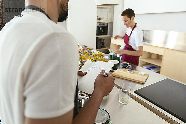 Close-up of man taking notes in a cooking workshop