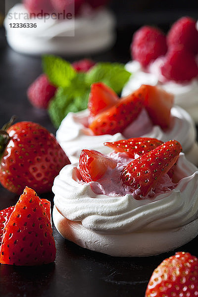 Meringue pastry garnished with whipped cream and strawberries