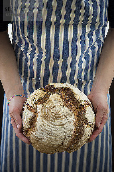 Woman holding homemade sourgough rye bread