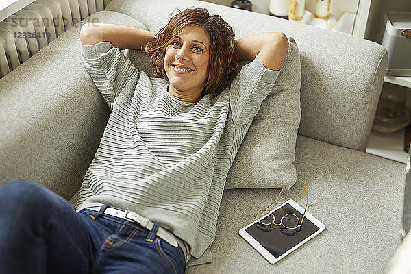 Portrait of smiling mature woman relaxing on couch