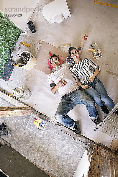 Happy couple renovating new home  taking a break  daydreaming