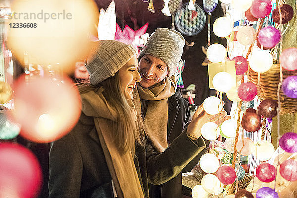 Young couple watching offerings at Christmas market
