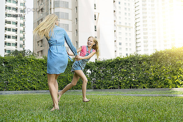 Happy mother and daughter having fun in urban city garden