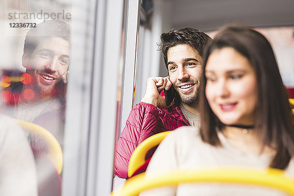 UK  London  portrait of smiling young man on the phone in a bus