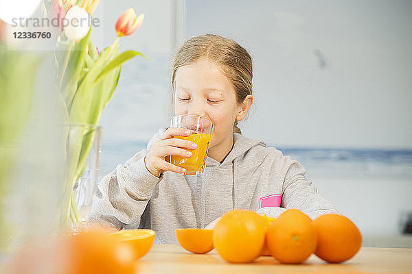 Portrait of girl drinking glass of orange juice
