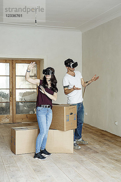 Couple moving into their new home  looking through VR glasses