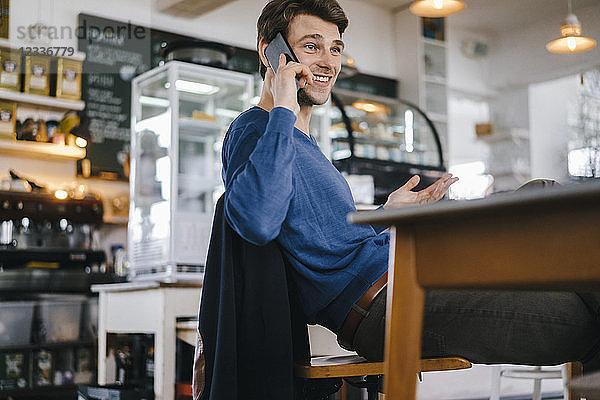 Smiling man in a cafe on cell phone