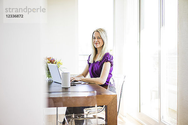 Portrait of smiling businesswoman working on laptop
