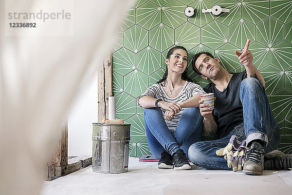 Couple renovating new house  sitting on ground planning bathroom