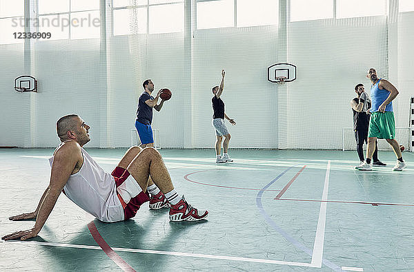 Basketball player sitting on court