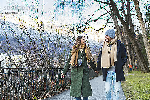 Austria  Innsbruck  happy young couple strolling together hand in hand at winter time