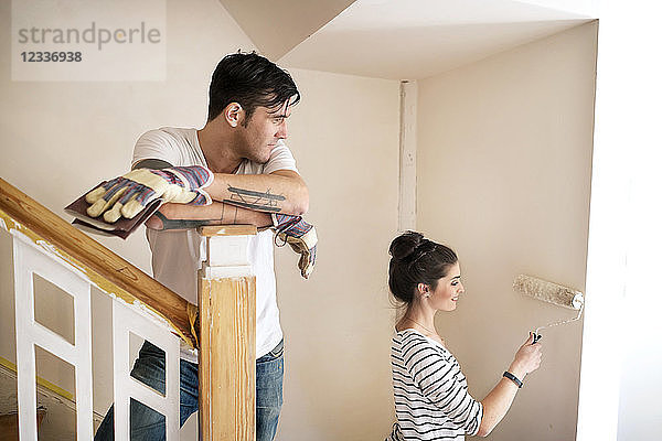 Young couple refurbishing new home  painting staircase