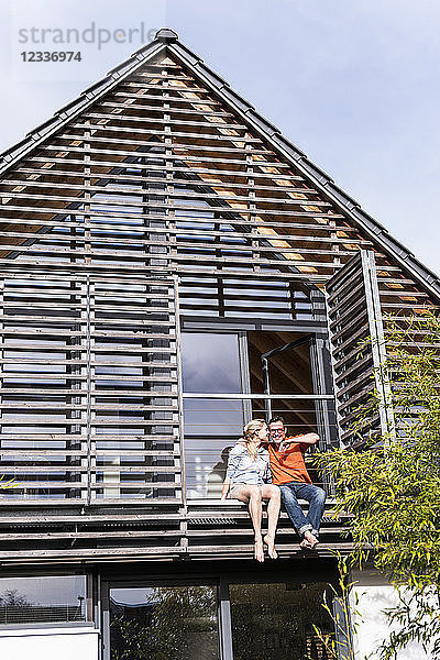 Mature couple relaxing together on balcony of their house