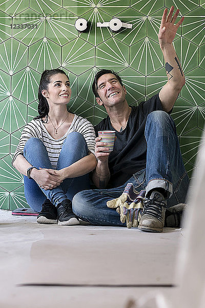 Couple renovating new house  sitting on ground planning bathroom