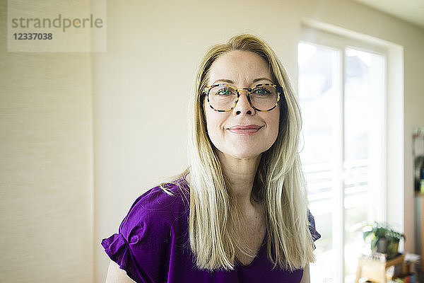 Portrait of smiling blond mature woman wearing glasses