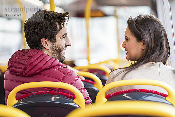 UK  London  happy young couple sitting side by side in bus