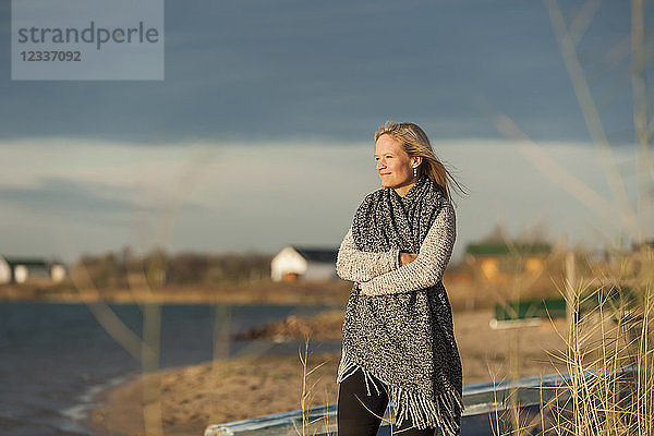 Woman standing at lake shore  enjoying the sun