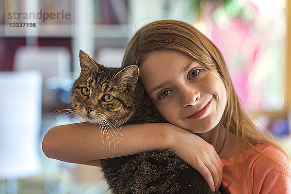 Portrait of smiling girl with her tabby cat