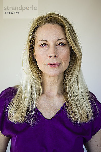 Portrait of blond mature woman wearing purple top