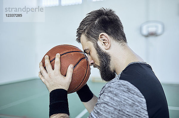 Man with basketball  closed eyes  indoor