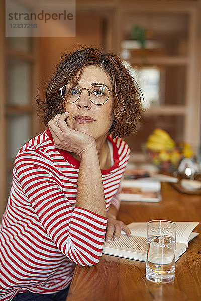 Portrait of mature woman with book at home