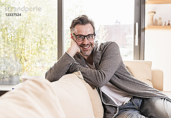 Portrait of smiling man relaxing on couch at home