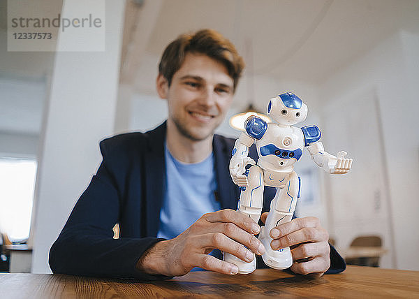 Smiling man holding robot