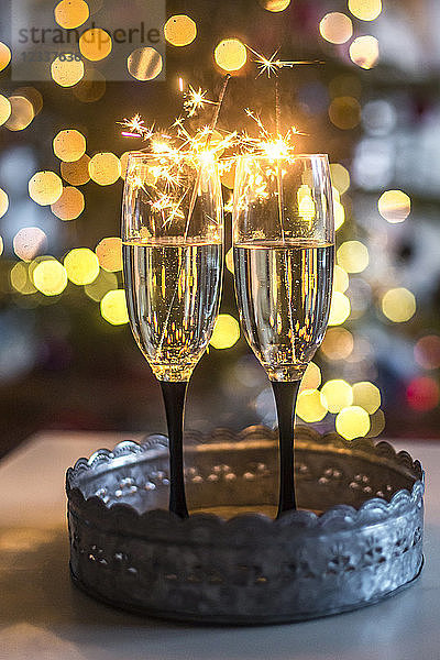 Two champagne glasses and sparklers in front of Bokeh