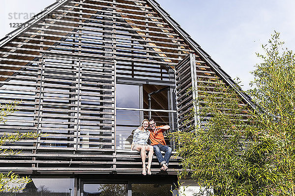 Happy mature couple relaxing together on balcony of their house