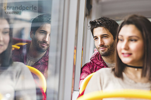 UK  London  portrait of smiling young man in bus looking out of window