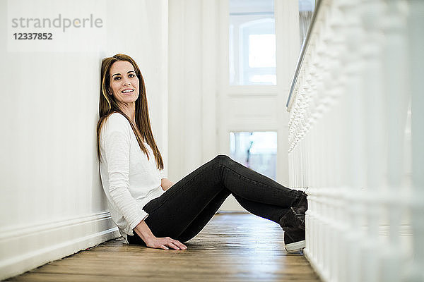 Portrait of smiling woman at home sitting on the floor